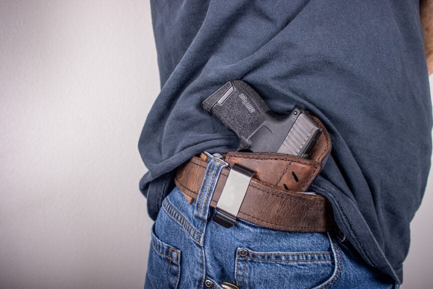 Why Is Gun Violence So Common In The United States? So many citizens have guns making it harder to control gun violence. Man with a gun in his belt.