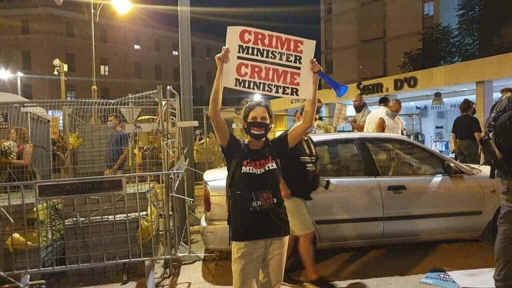 Israel’s Defense Minister Israel Katz Reveals Plan: Palestinians In ‘Concentration Camp’ Plan to push palestinians into rafah. A protester holds a sign that says crime minister during 2020 protests against netanyahu.