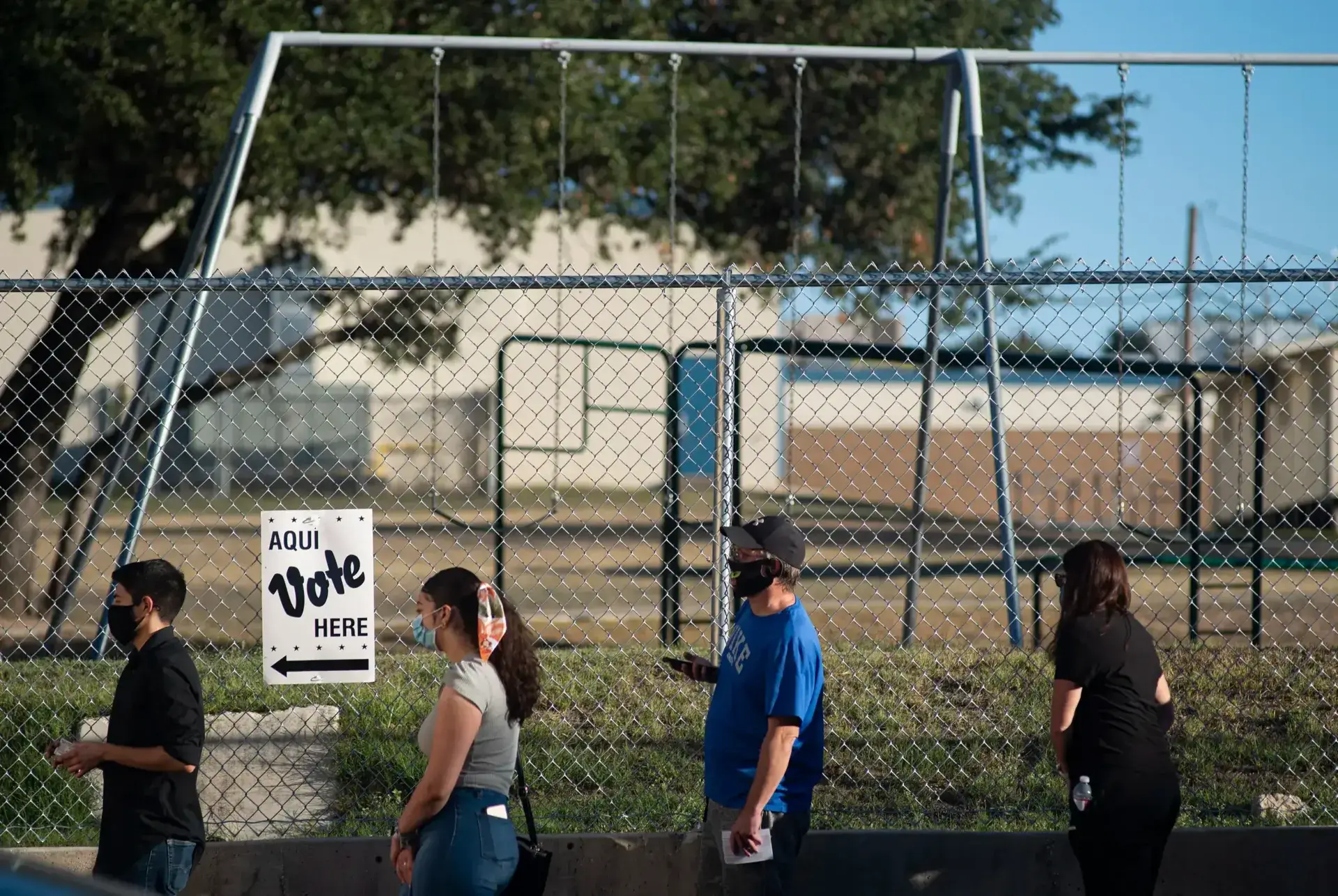 Voters wait in line outside cody public library in san antonio during the evening hours of election day on oct. 23, 2020.
