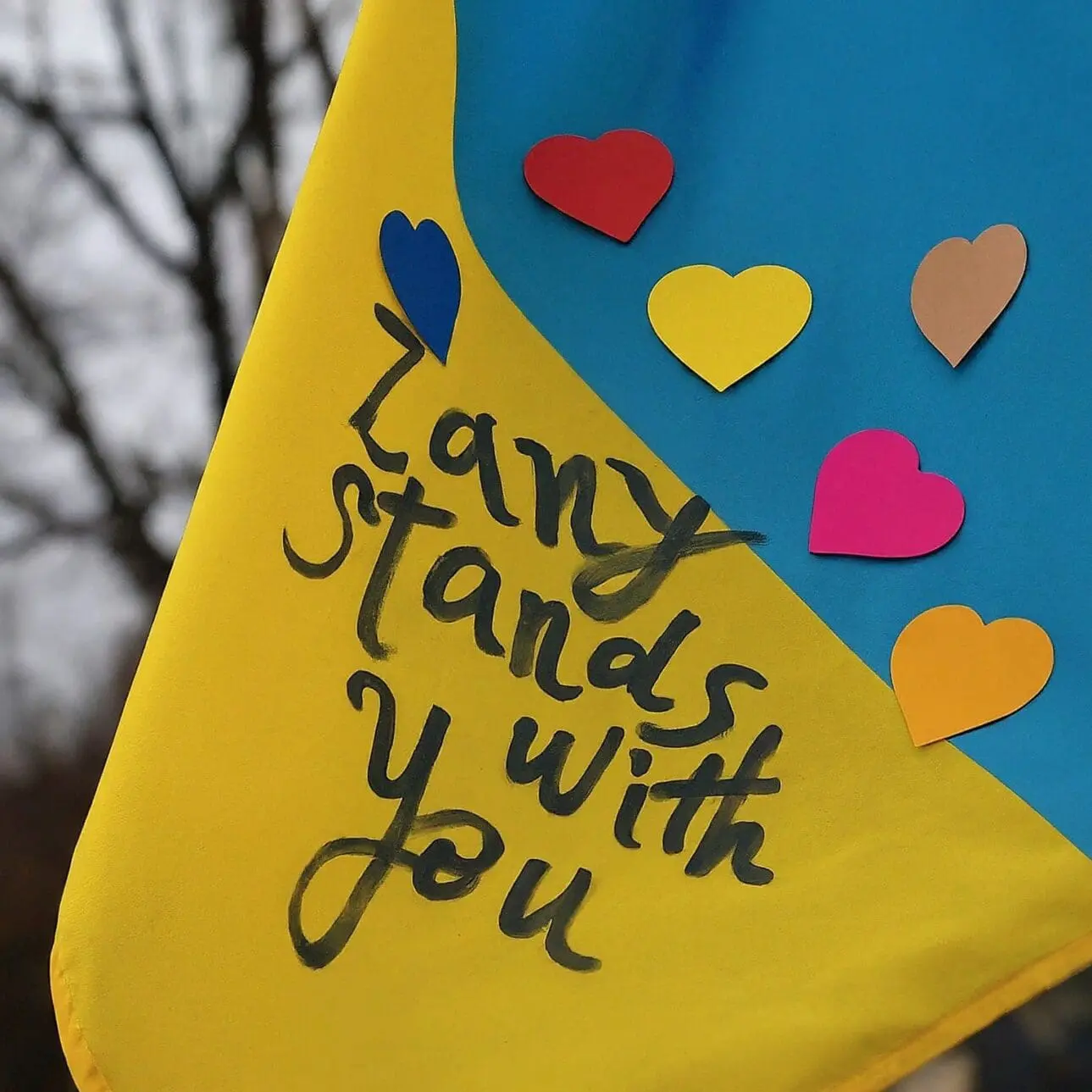 War in ukraine: ukranian flag with hearts and written in black marker: zany stands with you. ”
