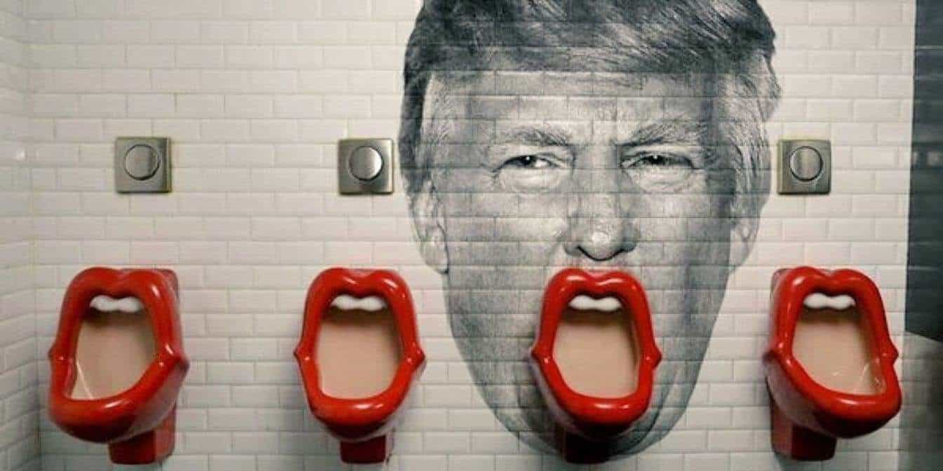 Trump's face painted on the wall behind a urinal so it looks like his mouth