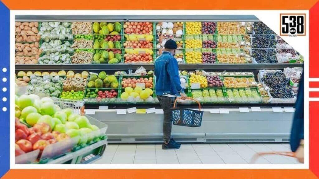 Man with a basket looking at produce in a grocery store
