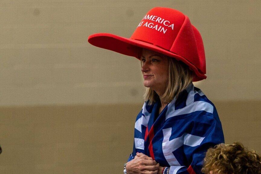 Maga woman wearing an oversized red maga hat in florid