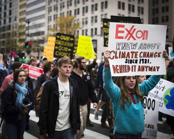 Exxon-Knew Clean energy. Climate protest with signs that say, exxon jnew