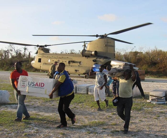 Understanding Foreign Aid: How Usaid Fosters Global Stability And Secures Our National Interests Foreign aid workers carry boxes marked with usaud from a helicopter in haiti
