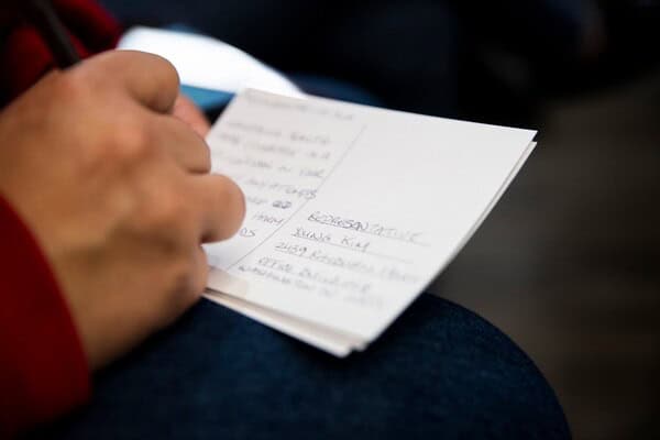 Woman writing postcard to stop medicaid cuts