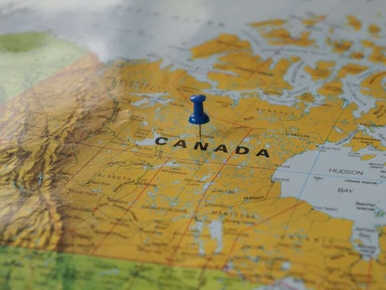 Yellow map of canada with a blue pin marking a location.