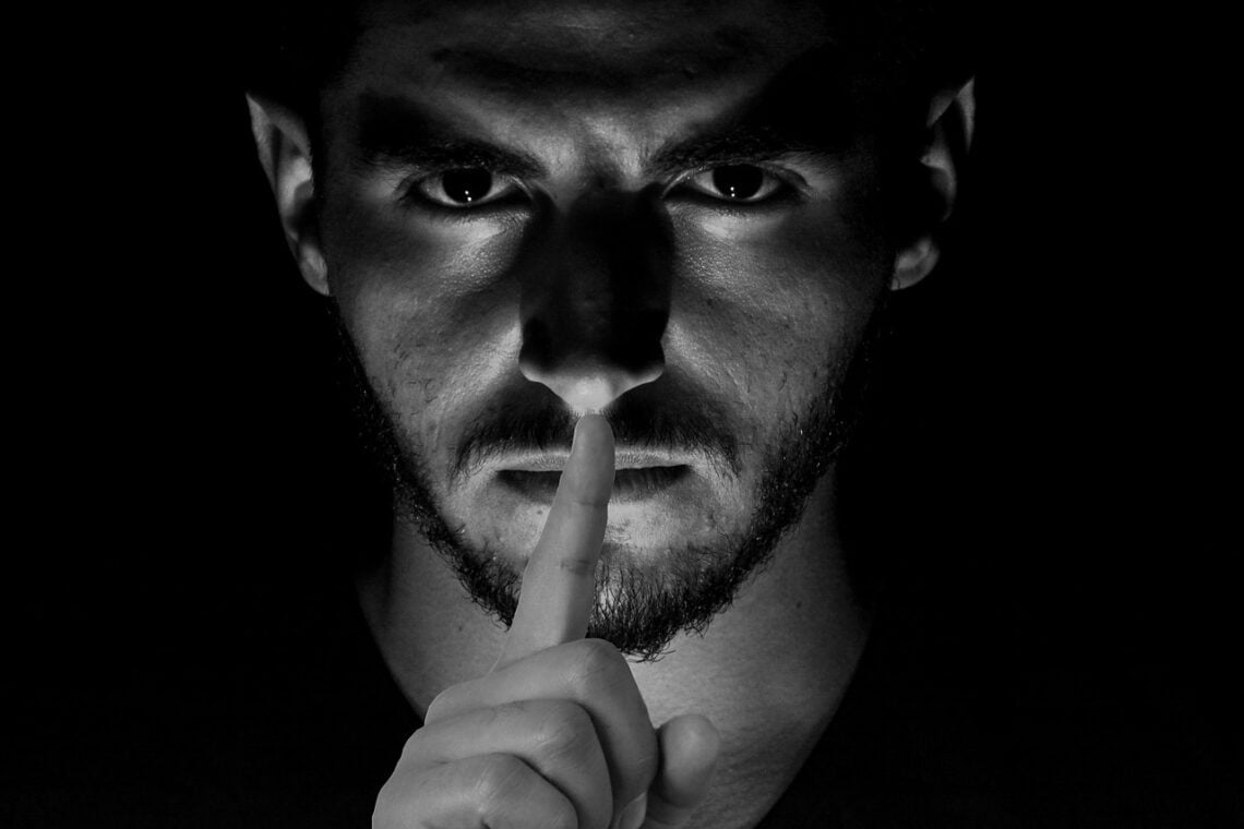 Trump’s Push For Orwellian History At The Smithsonian Smithsonian history dark photo of man with finger to his lips symbolizing censorship by microsoft