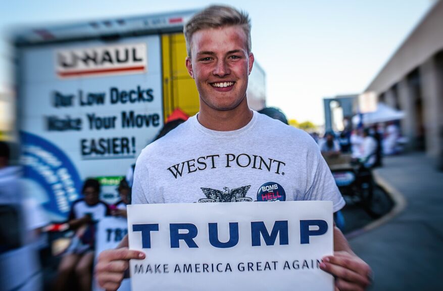 Donald trump at west point. A west point graduate holds a trump sign.