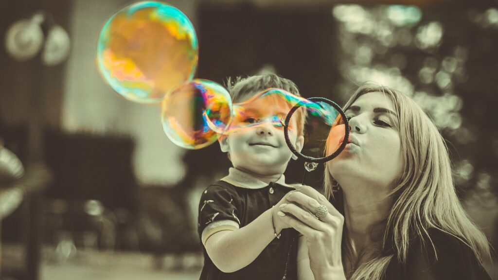 Mom holding a toddler, blows bubbles. Trump attacks college students who are parents.