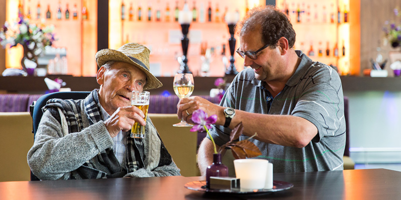 The Dementia Village In The Netherlands One of the residents enjoying a drink at the restaurant in the village.