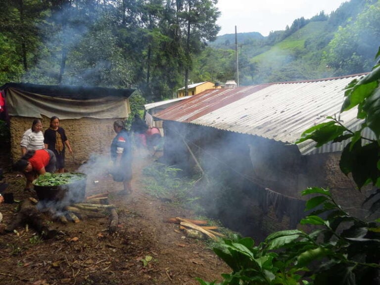 Sand dredgers women cooking in a large kettle over a fire outdoors in mexico