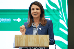 Ana toni speaking on stage behind a podium. Cop30